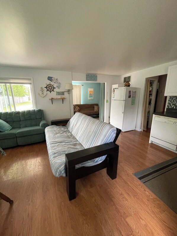 A compact living space with a sofa, a bed, a kitchenette, and a dining area. - Enjoy a Lake Huron view less than a minute walk to the beautiful sandy beach. (Au Gres)