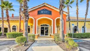 A building with a sign reading "Cenote Day Spa" with a central entrance, palm trees, and a parking lot. - Fun Family Themed Resort home close to Disney. Regal Palms Resort  (Davenport)