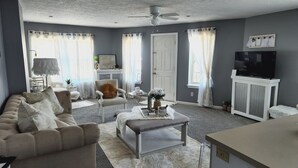 A living room with a sofa, a coffee table, a TV, and a fireplace.