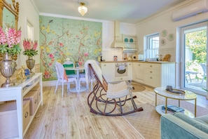A dining area with a table, chairs, and a decorative rocking chair. - Riverside, private boutique apartments with garden (Mosonmagyaróvár)