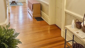 A hallway with wooden flooring, a bench, a table with baskets, and a potted plant. - Cozy, and private apartment near Lake Shelbyville (Shelbyville)