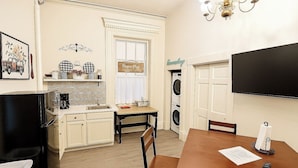 A compact kitchen with a refrigerator, sink, and a dining area with a table and chairs. - Cozy, and private apartment near Lake Shelbyville (Shelbyville)