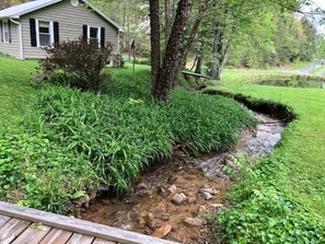 A house with a small stream running through a garden.