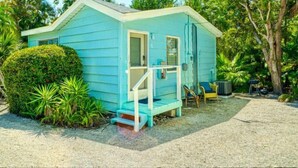 A small, single-story house with a porch, surrounded by dense tropical vegetation. - Brand New to the rental market ! (Sanibel)