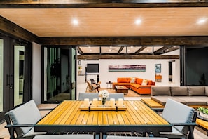 A modern living room with a wooden table, two sofas, and a TV.