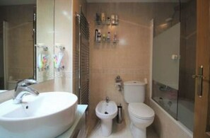 Tina con regadera, secadora de cabello, bidet, toallas 
