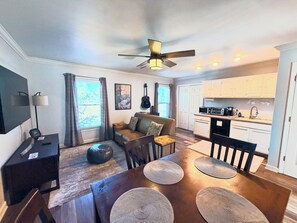 A modern living room with a sofa, coffee table, and dining area.