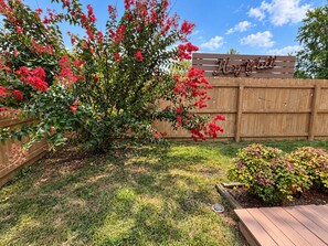 A backyard with a wooden fence, a sign reading 'Key Yard,' and a well-maintained lawn.