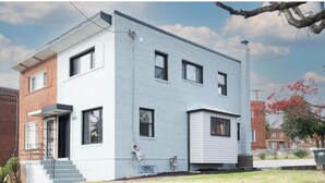 A two-story building with a flat roof, a front entrance with steps, and a garage. - Cozy Modern Beautiful Studio+Parking. Walk to DC Metro. Perfect for Long Stays! (Washington)