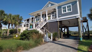 A two-story house with a covered porch, a staircase, and a garage. - Across from the beach luxury~ Folly Beach Stay (Folly Beach)