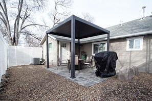 A covered patio area with a grill and outdoor seating. - Cozy home a mile from downtown. (Prescott)