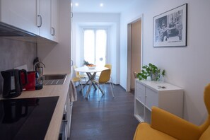 Uma cozinha moderna com área de jantar, um armário branco e um quadro na parede.