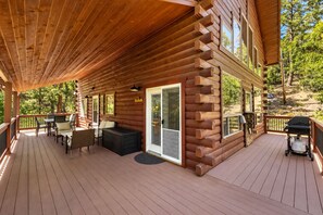 A wooden cabin with a deck, outdoor seating, and a grill. - Family Fun Log Cabin in the Pines - Game Room + Firepit  + Slide (Prescott)