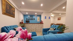 Un área de recepción con una pared azul, dos sofás azules y un mostrador.