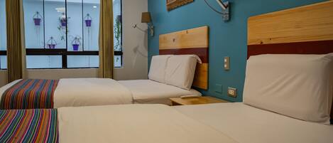 A hotel room with two beds, a window with curtains, a wall-mounted painting, and a wall-mounted lamp.