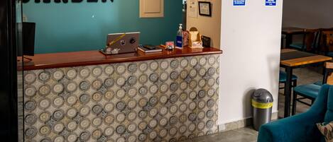 A reception area with a patterned wall, a clock, and a laptop on the counter.
