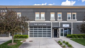 A building with a garage door labeled "THE CASCADE" and a sign for "DSO Discount SAFE Outlet."