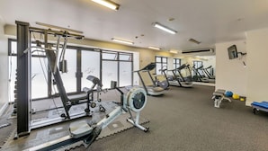 A gym with cardio machines, weightlifting equipment, and exercise balls. - Chic CBD Studio-Aircon-Wifi -Heated Pool (Auckland)
