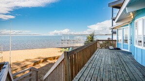 Une terrasse en bois offrant une vue sur une plage et l’océan.