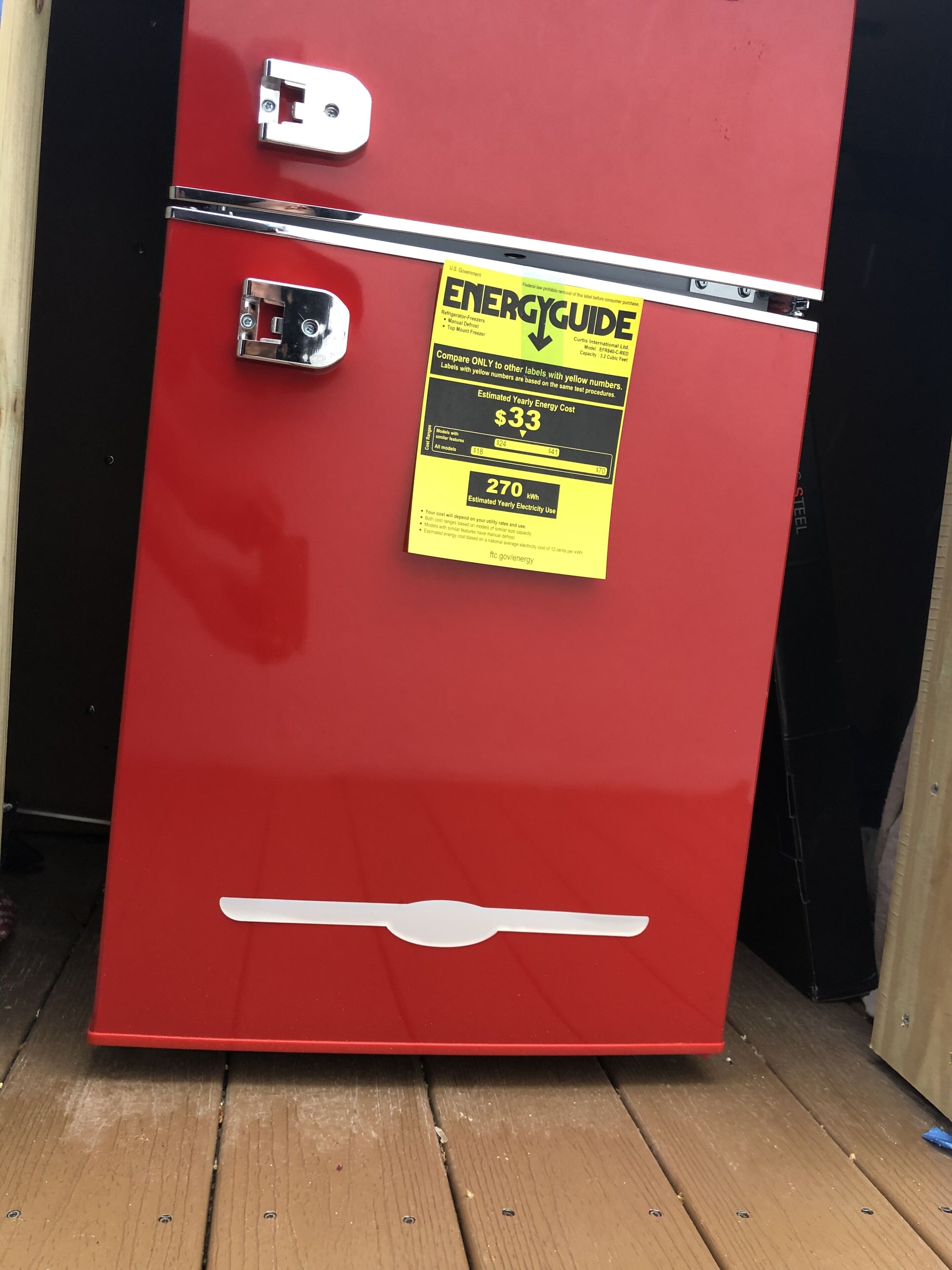 A red refrigerator with a yellow ENERGYGUIDE sticker on the door.