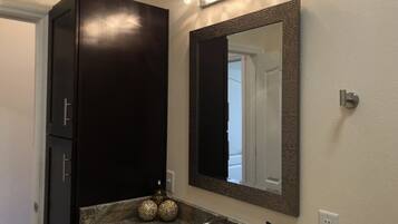 Een bad/douchecombinatie, een haardroger, handdoeken, zeep