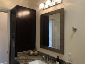 Een bad/douchecombinatie, een haardroger, handdoeken, zeep