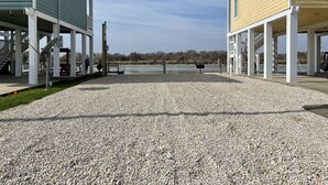 Un espacio al aire libre cubierto con piso de grava, bancos y vista a un cuerpo de agua.