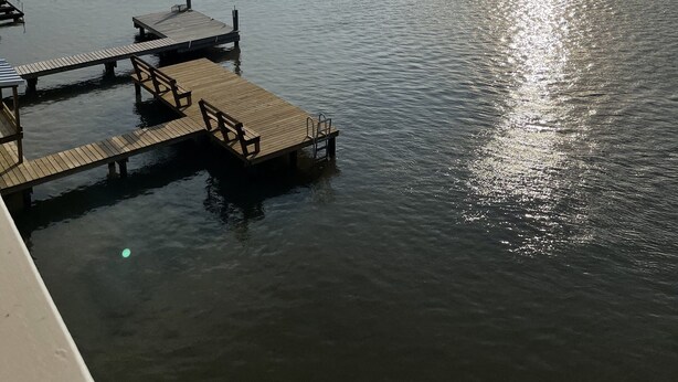 Un lago tranquilo con muelles de madera y cielo despejado.