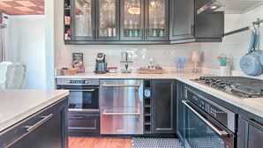 A modern kitchen with stainless steel appliances, dark cabinetry, and a built-in oven. - Chincoteague Island Cottage ~ 2 Mi to Beaches (Chincoteague)