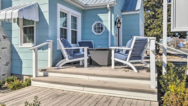 A blue house with a porch, white railings, and a small table with chairs. - Chincoteague Island Cottage ~ 2 Mi to Beaches (Chincoteague)