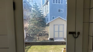 A white door with a small window, a brass doorknob, and a chain lock. - Best in the Bay!! 3B/1.5ba, Pet friendly Home (Alexandria Bay)