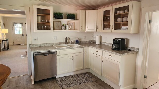 A compact kitchen with white cabinets, a dishwasher, a coffee maker, and a sink. - Best in the Bay!! 3B/1.5ba, Pet friendly Home (Alexandria Bay)