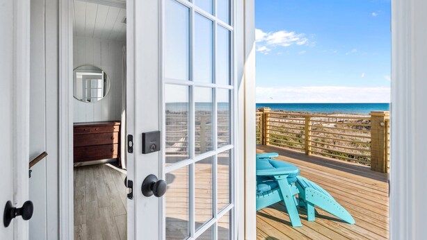 An open door leading to a balcony with a view of the beach. - Oceanfront Family Cottage: Hot Tub, Heated Pool. Game Room & Stunning Beach View (Atlantic Beach)