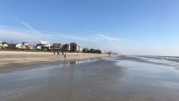 Une plage bordée de maisons et un ciel dégagé.