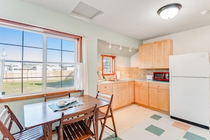 Enjoy meals in the kitchen with a dining table and chairs, microwave, and sink.