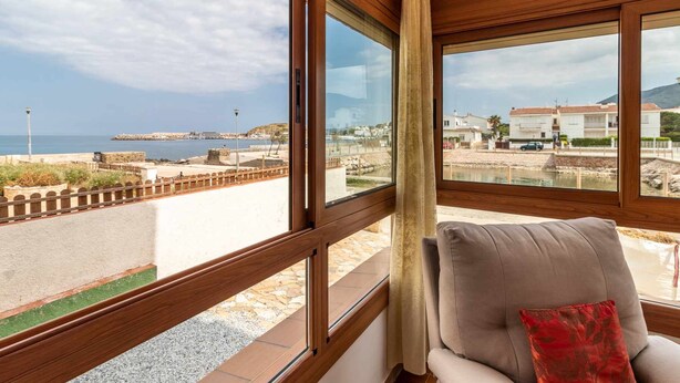Una habitación con amplios ventanales que ofrecen vistas al mar y a una ciudad costera.