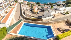 Un quartier résidentiel doté d’une piscine, d’une route sinueuse et offrant une vue sur la mer.