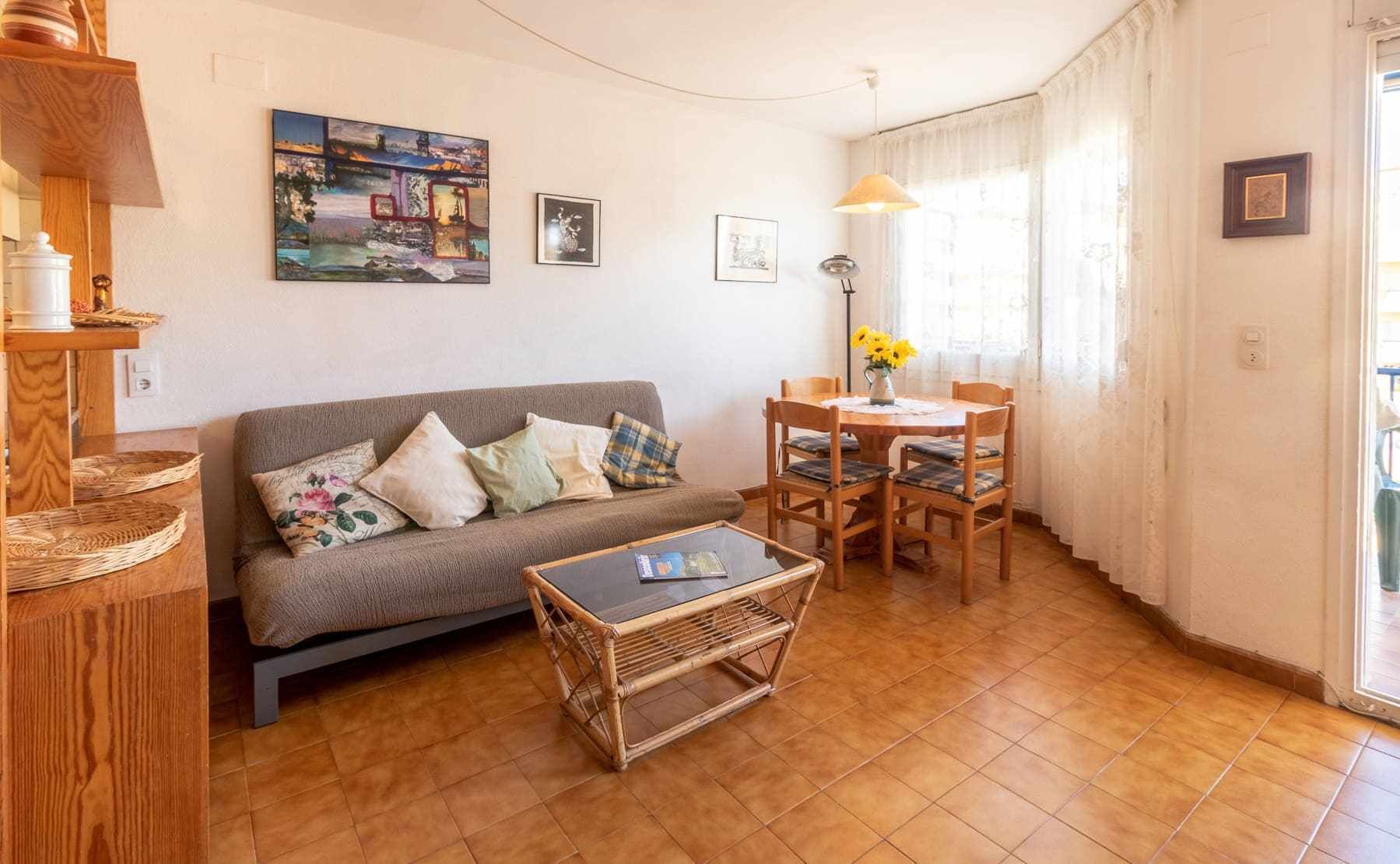 Een gezellige woonkamer met een bank, een salontafel en een eettafel met stoelen. Aan de muur hangt een schilderij en op de tafel staat een lamp.