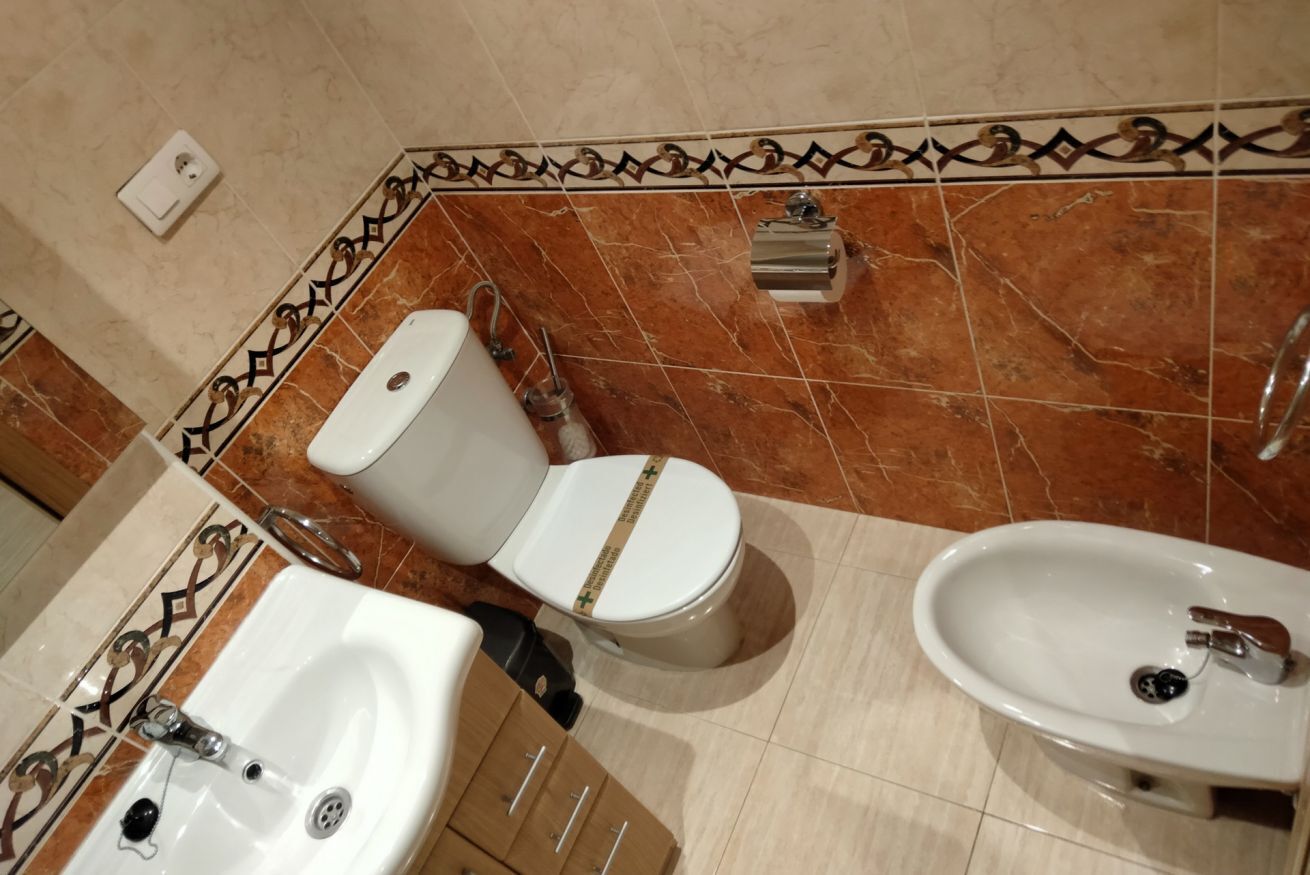 Un baño con inodoro, bidé y lavamanos.