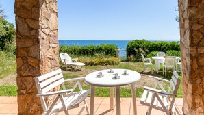 A patio with white chairs and a table, overlooking a clear blue sea. - Carboneras 48 - Apartment on the seafront (Llança)