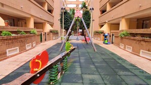 Un área de juegos infantiles con un balancín y una estructura para escalar.