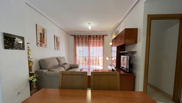 Un espace de vie compact comprenant un canapé, une table à manger et un téléviseur.