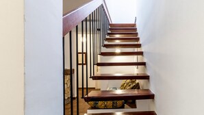 A wooden staircase with a handrail and a wall-mounted light fixture.