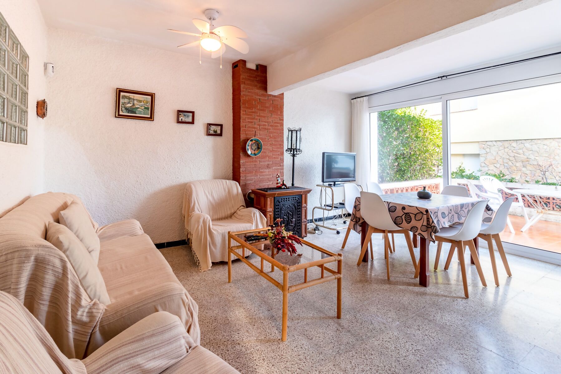 Ein Wohnzimmer mit einer Couch, einem Couchtisch, einem Fernseher und einem Essbereich mit Stühlen und Tisch.
