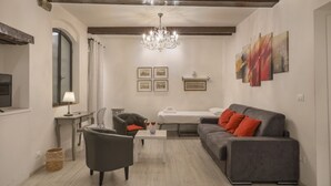 A modern living room with a sofa, armchair, coffee table, and a chandelier. - Florence Little Suite - Sweet Dreams in Florence (Firenze)