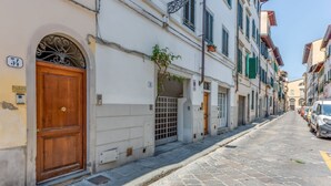 A narrow cobblestone street lined with historic buildings, a wooden door, and a number '34' sign. - Serenity - Sweet Dreams in Florence (Firenze)