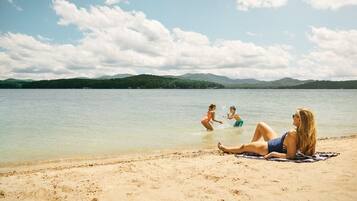Guests can enjoy a serene lakeside setting with calm water and a sandy shoreline.
