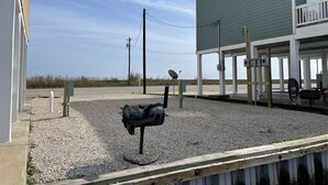A building with a green exterior and a covered area with a wooden deck. - “Reeling Em Inn” WATERFRONT RV HOOKUPS ON THE COLORADO RIVER<br>RV #2 (Matagorda)