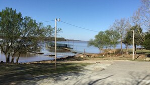 Una zona sul lago con un molo, alberi e cielo sereno.