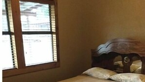 Un letto singolo con una testiera in legno in una stanza con una finestra.